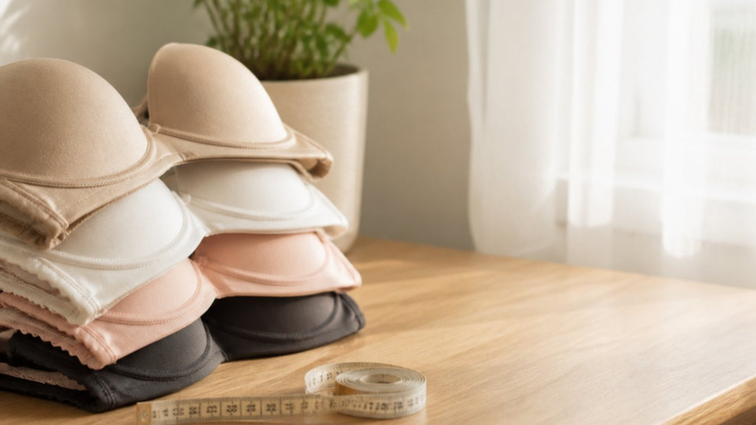 Folded bras and a measuring tape on a table, illustrating what causes saggy breasts